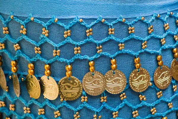 stock image Plenty of fake gold coins are on the scarf edges