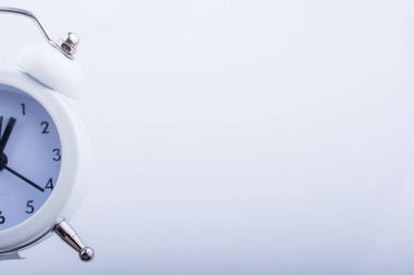 Bir çalar saat k beyaz arka plan üzerinde tutan çocuk