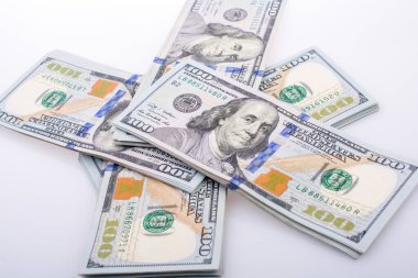 Beyaz zemin üzerine yerleştirilmiş Amerikan 100 dolarlık banknot demetleri