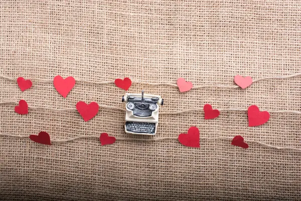 stock image typewriter and love concept with heart shaped papers on linen threads