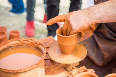 Potter 'ın elleri çömleğin kilini şekillendiriyor.