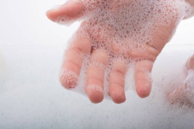 Köpüklü arka planda el yıkama ve sabun köpüğü.