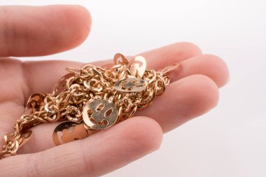 Altın renkli gülücükler Eldeki bir zincir üzerinde