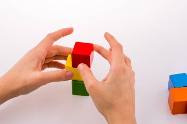 Beyaz arka planda renkli küplerle el oynamak