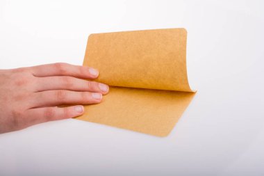 Beyaz arka planda bir sayfa kağıt tutarken