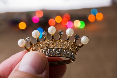 Renkli ışıkların elinde küçük taç