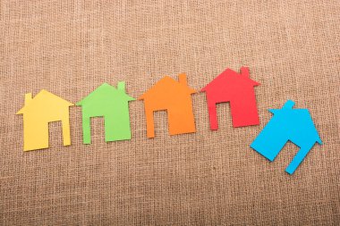 Tuvalin arka planında renkli kağıttan kesilmiş küçük bir ev şekli
