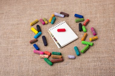 Boya kalemlerinin ortasındaki not defteri.