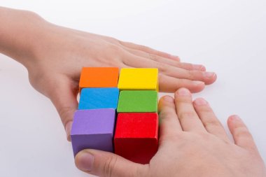 Beyaz arka planda renkli küplerle el oynamak