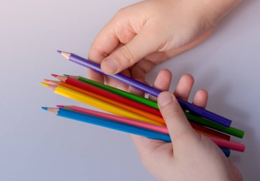 Beyaz arkaplana yerleştirilmiş el ele tutuşan kalemler