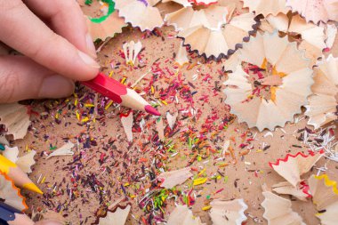 Kalem talaşı olan bir defterin üzerinde Renkli Kalem 'i tutarken