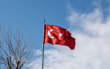 Gökyüzünde beyaz yıldız ve ay bulunan Türk ulusal bayrağı