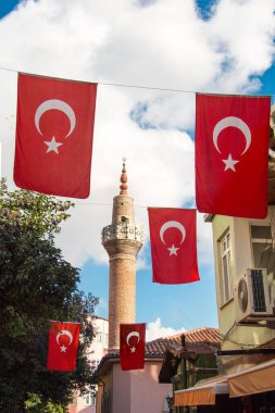 Bir minare bir iple bir direğe Türk ulusal bayrak dayan