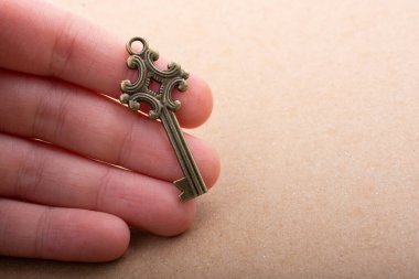 Elinde eski moda dekoratif bir anahtar var.