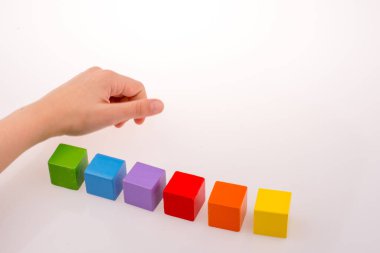 Beyaz arka planda renkli küplerle el oynamak