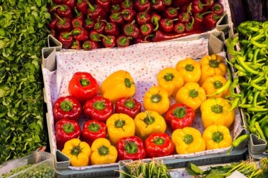 Pazar standında bulunan kırmızı ve sarı biber