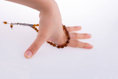 Beyaz bir arka plan üzerinde bir tespih tutan el