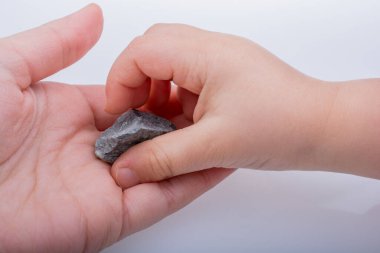 Küçük bir taş elinde tutan el