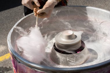 Sokak pazarında pamuk şeker yapma süreci. Sokak yemekleri ve yiyecekler.