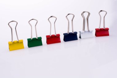 Beyaz arkaplanda renkli ataçlar