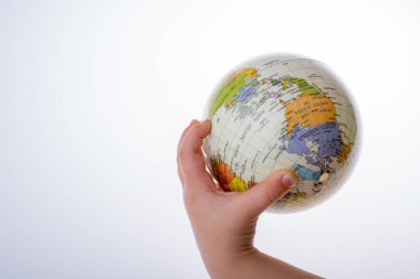 Beyaz arka planda bir küreyi tutan çocuk