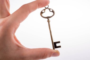 Beyaz arka planda eski moda metal bir anahtar tutan el.