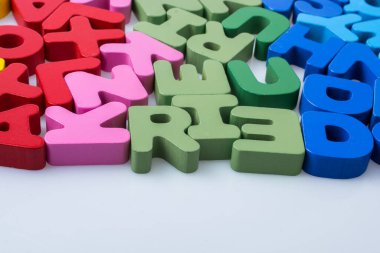 Beyaz arkaplana rastgele dağılmış renkli harf blokları