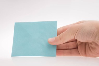 Beyaz bir arka plan üzerine açık mavi renk dikdörtgen kağıt tutan el