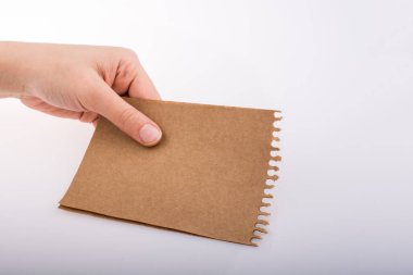 Beyaz arka planda bir sayfa kağıt tutarken