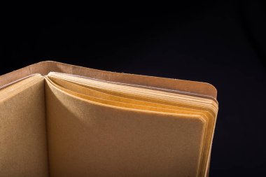 Siyah arkaplanda kahverengi renkli defter açık