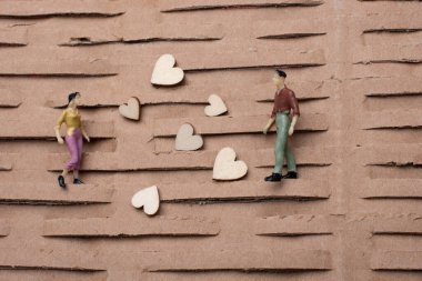 Küçük bir kadın ve erkek figürü. Minyatür model ve kalp aşk konsepti.