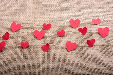 Love concept with heart shaped papers on linen threads clipart