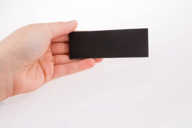Beyaz bir arka plan üzerinde siyah kağıt tutan el
