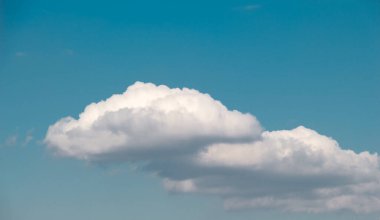 Beyaz renkli bulutlar gündüz vakti mavi gökyüzünü kaplar.