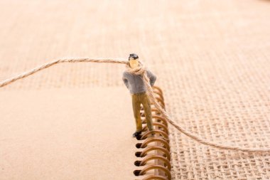 Heykelcik adam boynuna bir ip ile