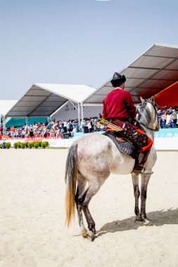 Osmanlı atlısı etnik kıyafetleriyle atına biniyor.