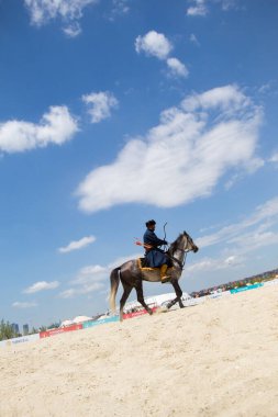 Atlı okçu at sırtında etnik kıyafetleriyle geziyor.