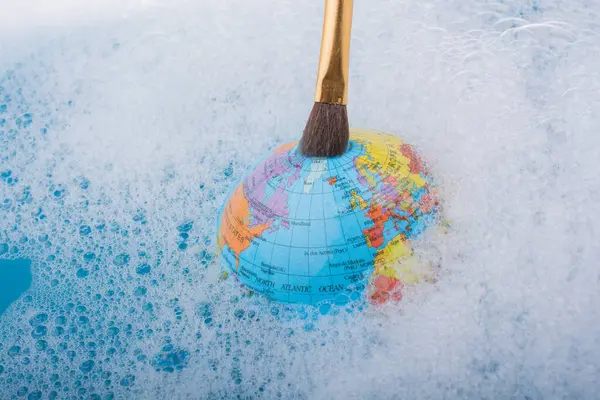 Dünya bir su üstüne yerleştirilen boya fırçası köpükle kaplı
