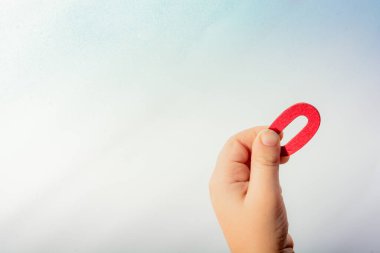 Bir çocuğun elinde tahtadan yapılmış 77 numara.