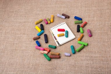 Boya kalemlerinin ortasındaki not defteri.