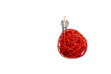 Beyaz arka planda iplik makarasında duran bir adam.