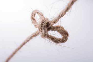 Açık renk arka plan üzerinde düğüm olarak bağlı iş parçacığı