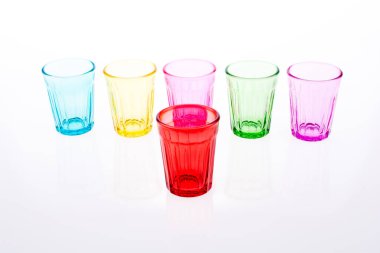 Beyaz arka plana dizilmiş renkli içki bardakları