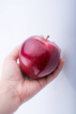 Güzel bir Kırmızı elma beyaz bir arka plan üzerinde tutan el