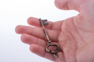 Beyaz arka planda eski moda metal bir anahtar tutan el.