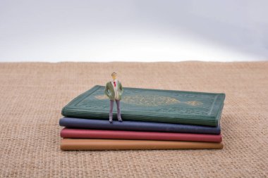 Adam heykelcik ayakta tuval üzerine küçük kitaplar