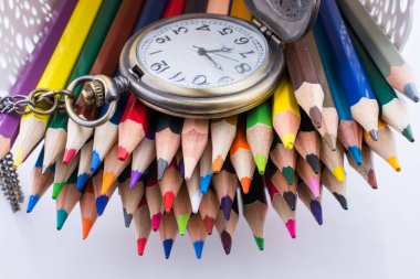 Retro tarzı klasik cep saati ve renk kalem beyaz arka plan üzerinde