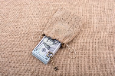 Retro anahtar ve bir çuval dolusu Amerikan doları tuvalde.