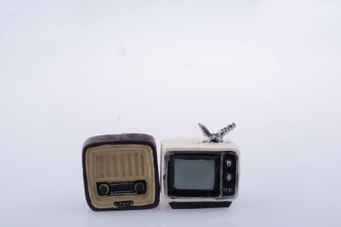 Beyaz arka planda küçük bir televizyon ve radyo modeli