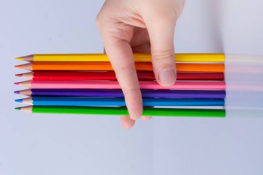 Beyaz arkaplana yerleştirilmiş el ele tutuşan kalemler